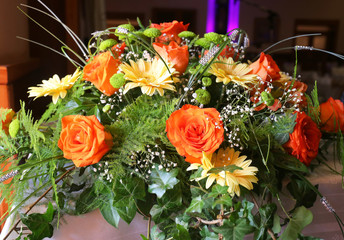 Flower composition made with orange roses and other flower