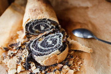 Tasty roll with poppy seeds on baking paper
