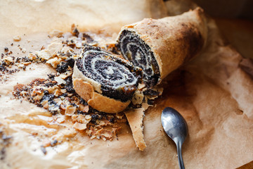 Tasty roll with poppy seeds on baking paper