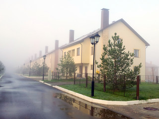 cottage village in the fog in the summer