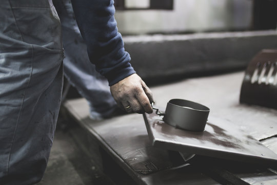 Metallurgy Industry. Factory For Production Of Heavy Pellet Stoves And Boilers. Manual Worker Sandblasting Parts Before Panting. 