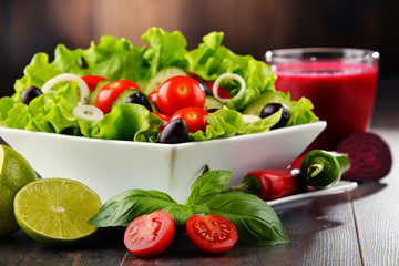 Composition with vegetable salad bowl and glass of juice