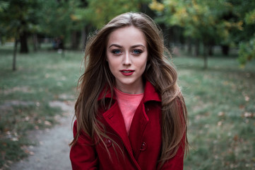 Naklejka premium portrait of beautiful girl with blue eyes in red