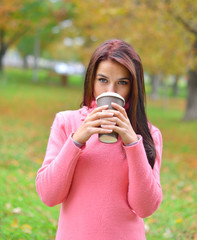 woman in autumn outdoors with cup of coffee