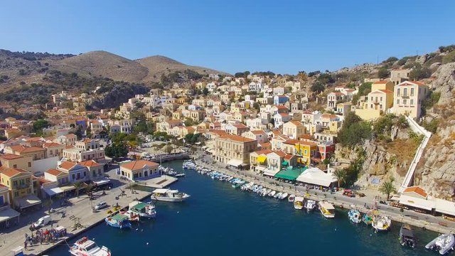 Symi island - Aerial footage of Colorful houses and small boats at the heart of the village