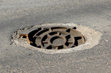 Damaged manhole cover in a city street