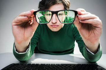 Nerdy guy with green data flow in his glasses