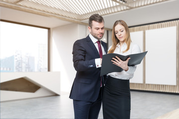 Two people discussing work issues in office lobby