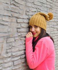 Portrait of young pretty funny smiling girl in cold weather dressed in color clothes and warm hat. Young happy woman having fun outdoor