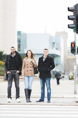 Two young bussinesmans and woman crossing the road