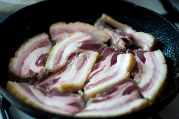 Frying streak of lean (fatback) on pan