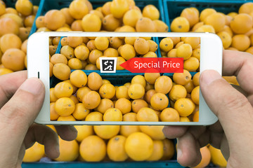 Augmented reality marketing concept. Hand holding smart phone use AR application to check special price of oranges in retail fresh mart store or fresh market mart
