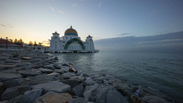 Time lapse 4k Footage of Beautiful Sunrise At Malacca Straits Floating Mosque, or Masjid Selat Melaka. Showing a moving and changing color clouds. 
