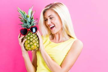 Happy young woman holding a pineapple