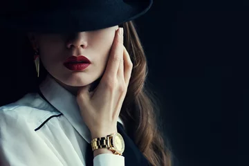 Foto op Plexiglas Vrouwen Indoor portret van een jonge mooie modieuze vrouw met stijlvolle accessoires. Verborgen ogen met hoed. Vrouwelijke mode, beauty en reclame concept. Detailopname. Ruimte voor tekst kopiëren