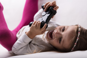 little girl playing videogames at home