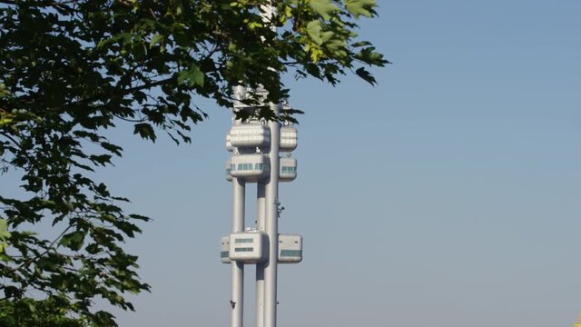 A dolly shot of the Zizkov tower with a tree in the foreground. Prague, Czech Republic. 4k.