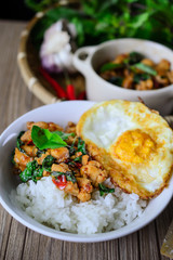 Stir Fried Basil Cicken with Rice and Egg on wooden, Thai Famous