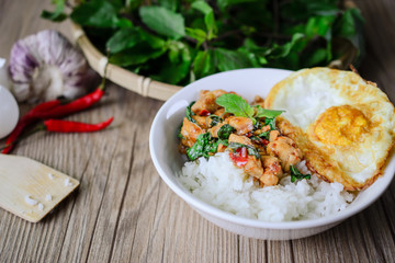 Stir Fried Basil Cicken with Rice and Egg on wooden, Thai Famous