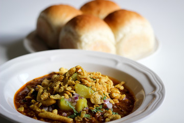 Misal Pav - Indian Spicy Breakfast Dish, Mumbai Street Food (Soft Bread served with spicy tangy curry with sprouts and fried crispy toppings)