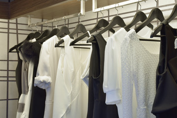 Black and white cloths hanging in closet