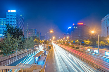 blurred traffic light trails on road at night in China.