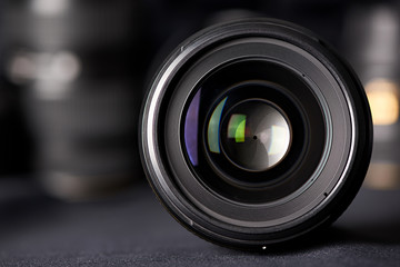 Photo lens front view on blurred texture