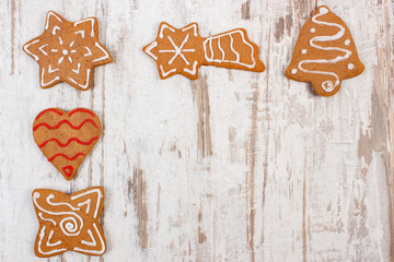 Fresh baked decorated gingerbread on old wooden background, christmas time