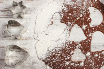 Dough for Christmas gingerbread and cookie cutters on old board