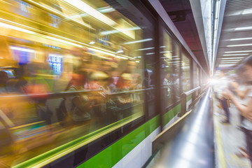 Blurred train at night leaving station in China.