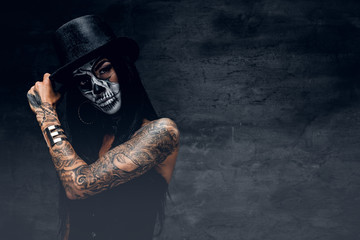 A girl in stylish top hat with skull make up.