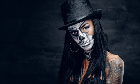 A girl in stylish top hat with skull make up.