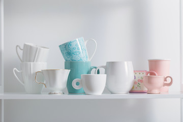 Clean dishes on white wooden shelf