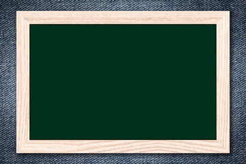 Chalkboard or Empty bulletin board with a wooden frame on denim jeans background with copy space for text or image.