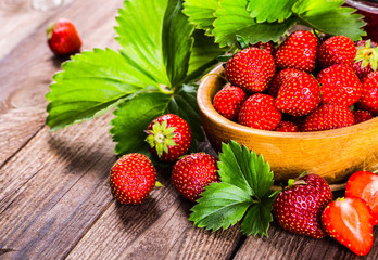 Strawberry on wood background. Strawberry with green leaves flow
