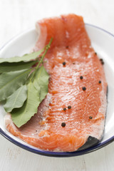fresh salmon on white dish on wooden background