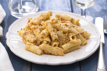 pasta with chicken on white dish on wooden background