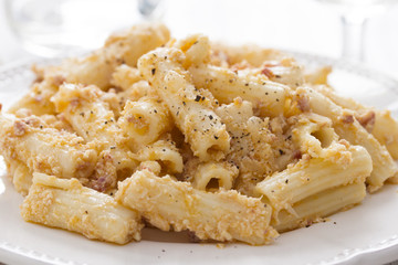 pasta with chicken on white dish on wooden background