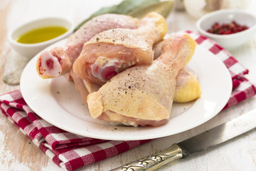 raw chicken on white dish on wooden background