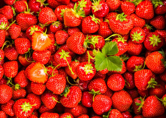 Strawberry on wood background. Strawberry with green leaves flow