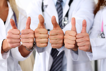 Three medicine doctors show OK sign with thumb up