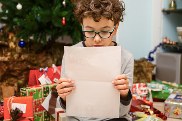 Bambino che legge la lettera di Babbo Natale