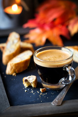 Cup of espresso coffee with almond cantucci or cantuccini biscuits with autumn leaves at the...