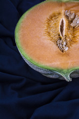 One half of an orange melon on the deep blue background