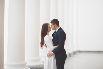 Beautiful couple, bride and groom posing near big white column