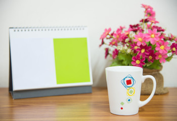  flowers with coffee cup on workspace.