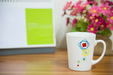  flowers with coffee cup on workspace.