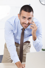 Happy businessman working in his office on the laptop