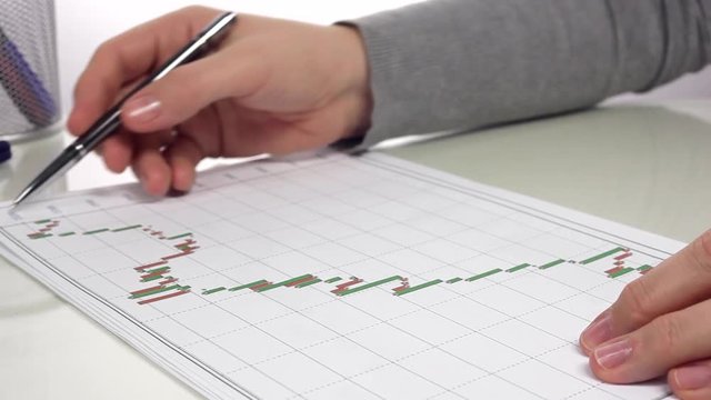 Businessman Analyzes Report/Businessman looks at the graphs and makes corrections. Close up