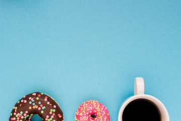 Sweet donuts with coffee on the blue background.